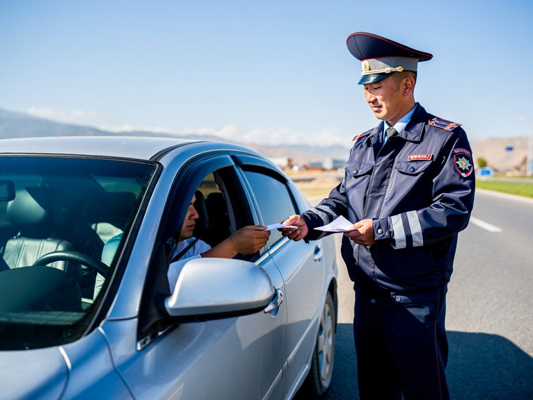 ПДД Кыргызстана 2025: турист общается с сотрудником ГАИ.